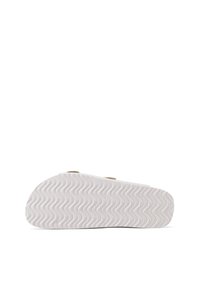 Soletta di gomma bianca con una texture ondulata e forma arrotondata. Presenta accenti decorativi beige e due aperture per le cinghie per un maggiore comfort.