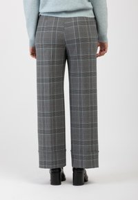 Pantaloni grigi a quadri con linee azzurro chiaro, design a gamba larga e risvolti, realizzati in un tessuto morbido, abbinati a tacchi neri.