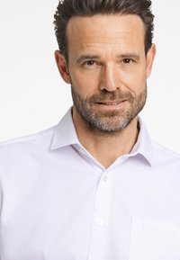 Wit overhemdd blouse met een textuurpatroon, voorzien van een kraag en een borstzak. Zacht, lichtgewicht materiaal, geschikt voor formele of casual gelegenheden.