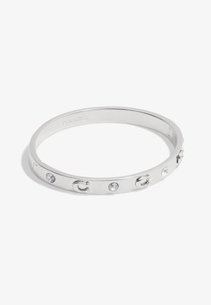 Silberne Metallarmband mit glatter Oberfläche, verziert mit klaren Kristallen und einem Logo-Akzent. Das Design ist kreisförmig und schlank mit einem minimalistischen Stil.