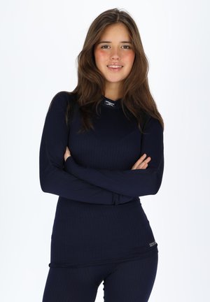 Navy long-sleeve top with ribbed texture and a round neckline, paired with matching bottoms. Features logo detail on the hem.