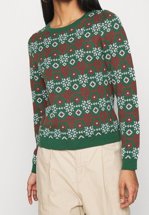 Pull en tricot vert présentant un motif en rouge, blanc et bleu, avec un col rond et une bordure côtelée.