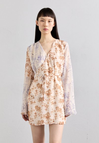 Floral wrap dress in beige and lavender with long sleeves, tie waist, and a mix of intricate flower patterns across the fabric.