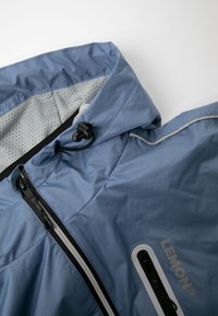 Lichtblauwe waterdichte jas met een getextureerd oppervlak, capuchon, mesh voering en zwarte accessoires; voorzien van een voorrits en logodetail.