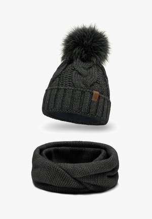 Black knitted beanie with a faux fur pom-pom and ribbed cuff, paired with a matching black infinity scarf, both featuring a textured pattern.