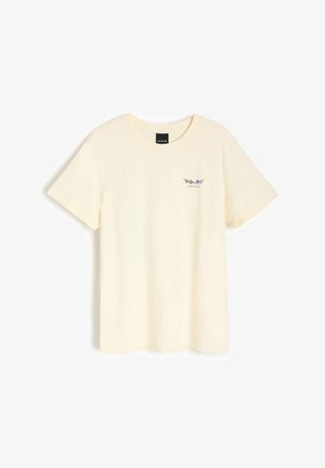 Jasnożółta bawełniana koszulka z krótkim rękawem i okrągłym dekoltem. Posiada mały nadruk na piersi. Miękka faktura, minimalistyczny styl.