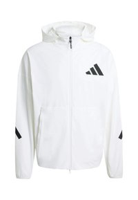 Biela ľahká bunda s kapucňou, s čiernym logom Adidas a diagonálnymi prvkami na rukávoch, predný zips a dve vrecká.