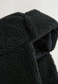 Black fleece jacket with a textured surface; features a quilted interior. The design includes a high collar and a cozy fit.