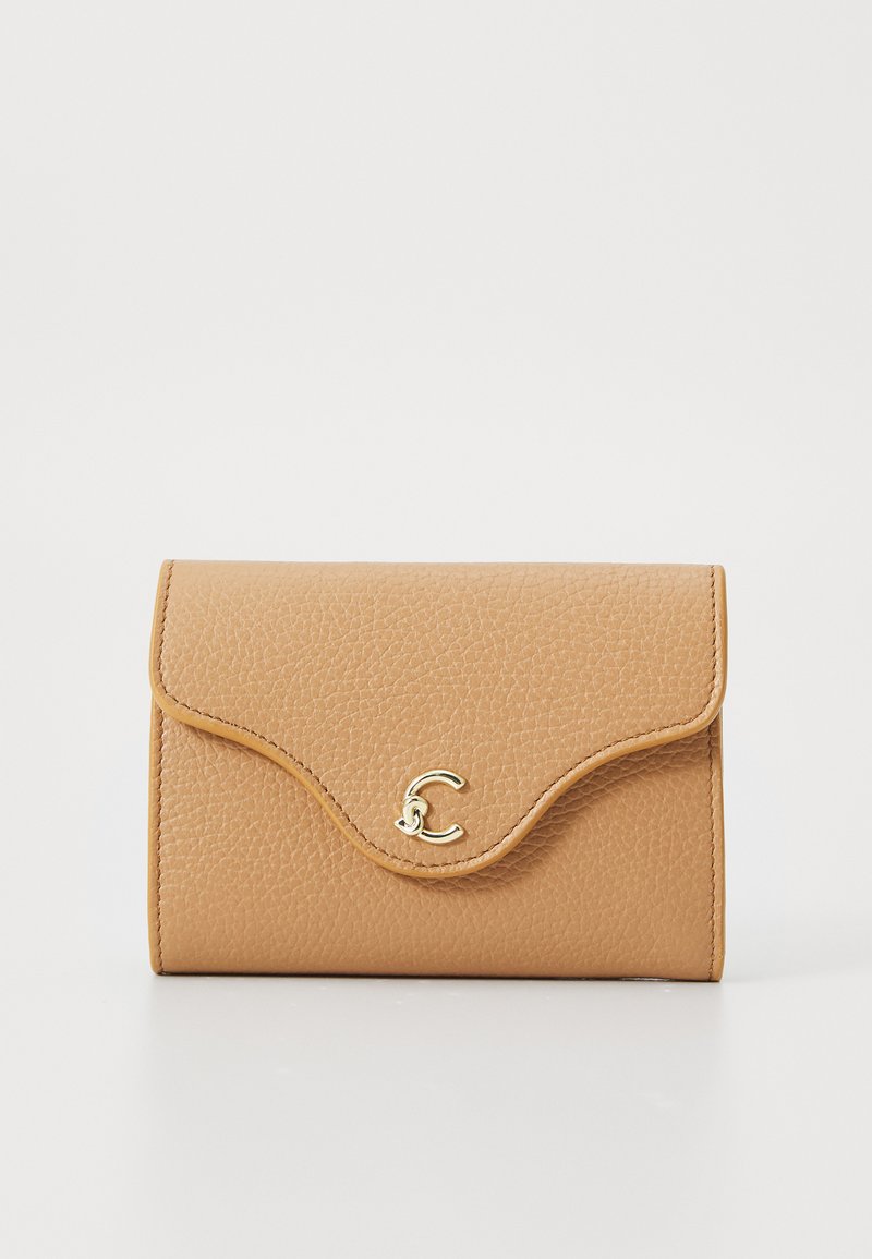 Tan leather wallet with a textured finish, curved flap closure, and a gold-tone logo accent at the front. Compact, rectangular shape.