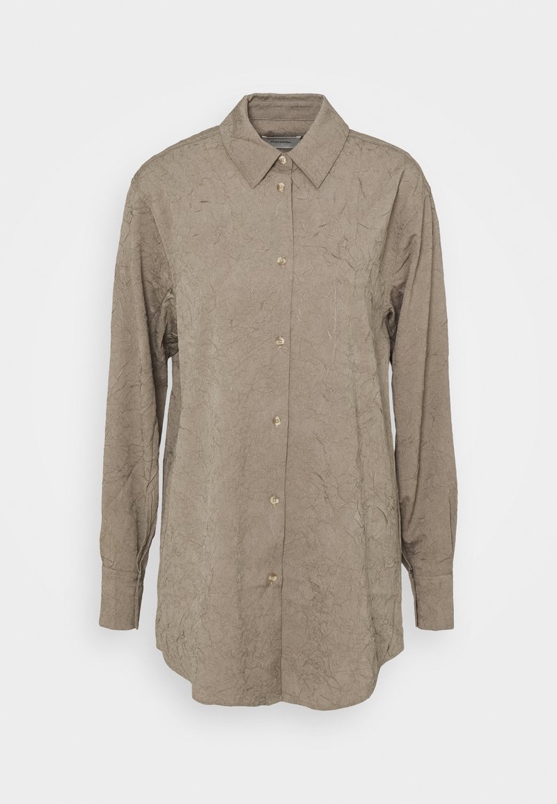 Syntetisk skjorta i ett skrynkligt, ljusbrunt tyg. Har en klassisk krage, långa ärmar och fem guldknappar fram.