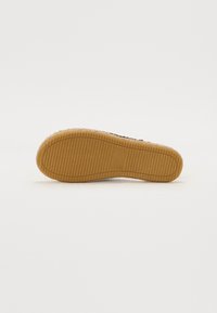 Talpa de pantof din cauciuc cu un model texturat și canelat. Culoarea este bej, cu o finisare netedă și formă rotunjită, concepută pentru aderență și durabilitate.