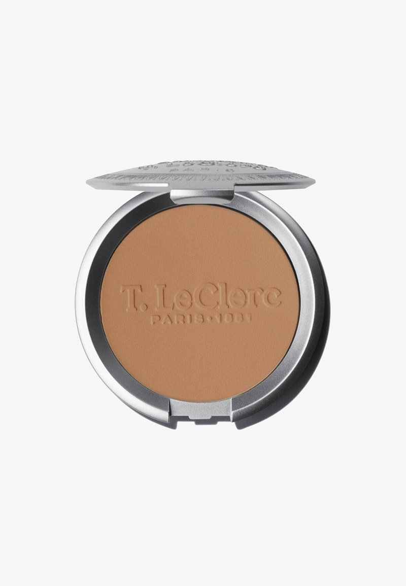 Kompaktpuder mit einer glatten, matten, mittelbraunen Oberfläche. Rundes Design, silberne Metallverpackung mit eingeprägtem Branding auf der Oberfläche.