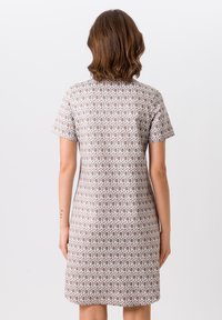 Robe à manches courtes en tissu à motifs, présentant un design géométrique dans des tons de marron clair et blanc, avec une silhouette droite et longueur genou.