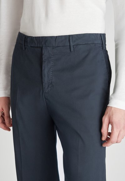 Pantaloni navy realizzati in tessuto leggero, con una finitura piatta, tasche laterali e una texture liscia. Passanti per cintura visibili in vita.