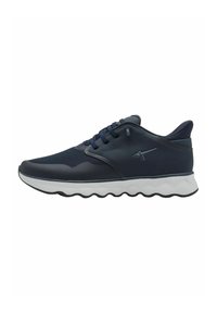 Baskets de sport navy avec tige en mesh et synthétique, semelle blanche rembourrée, accents texturés et système de laçage. Détail du logo sur le côté.