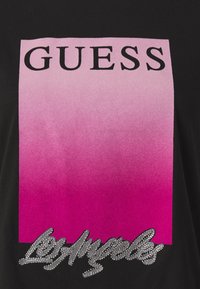 Zwarte t-shirt met een roze gradient vierkant met "GUESS" in het zwart en "Los Angeles" eronder in zilveren strassstenen.