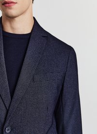 Marineblauer, strukturierter Blazer mit kleinem Karomuster, einreihiger Knopfleiste und Kniesteg-Revers. Enthält eine Brusttasche und glattes Stoffmaterial.
