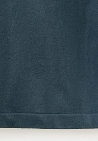 Tissu tricoté bleu sarcelle foncé avec une texture côtelée verticale uniforme et un ourlet plié en bas.