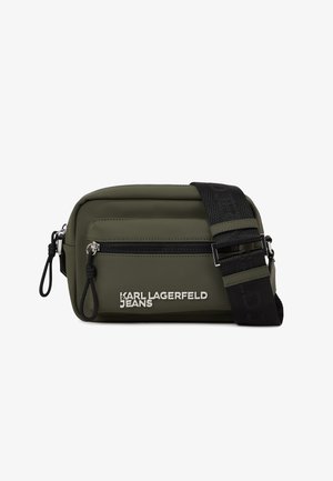 Zöld nylon keresztpántos táska elülső cipzáras zsebbel. Jellemzője a logó részlet és a texturált elemekkel ellátott állítható fekete pánt.