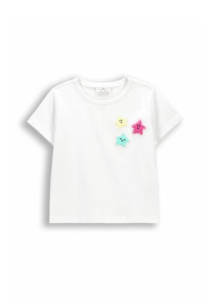 Biały t-shirt dla małego dziecka z krótkim rękawem z trzema uśmiechniętymi naszywkami w kształcie gwiazdek w kolorze żółtym, różowym i niebieskim na piersi.