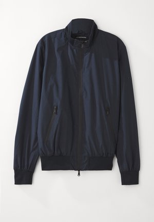 Marineblaue Bomberjacke mit einem Reißverschluss vorne, geripptem Kragen und Bündchen. Verfügt über zwei seitliche Reißverschlusstaschen und einen glatten, leichten Stoff.