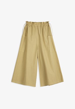 Pantalon beige à jambes larges avec une taille élastique et un cordon de serrage, doté de grandes poches latérales et d'une coupe ample.