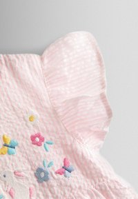 Ružové pruhované šaty s volánovými rukávmi, s farebnou kvetinovou a motýľovou výšivkou na živôtiku. Textúrovaná bavlnená tkanina.