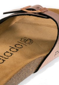 Sandal in finta pelle di serpente marrone con tomaia rosa chiaro, soletta in sughero e hardware color rame. Presenta una suola imbottita e una suola testurizzata.