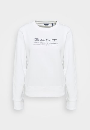 Biała bluza z długim rękawem z nadrukowanym na piersi granatowym napisem "GANT American Sportswear Since 1949".