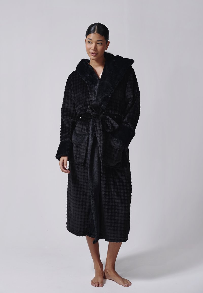 Sort, tekstureret badekåbe med sjalskrave, bælte og sidelommer. Blødt, plyssede stof med ternmønster og længde til midt på læggen.