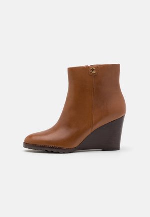Botte compensée en cuir marron à la cheville avec fermeture éclair latérale et talon en bois foncé, ornée d'un petit logo RL doré près du bord supérieur.