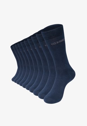 Huit paires de chaussettes bleu marine alignées en rang avec un logo discret de la marque près du bord supérieur.