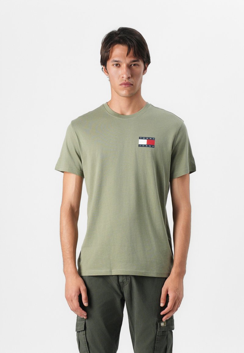 Olive green cotton t-shirt with short sleeves and a crew neck, featuring a small stitched logo in red, white, and blue on the left chest.