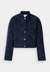 Μπλε ναυτικό cropped σακάκι με περίπλοκη υφή λουλουδιών, που διαθέτει όρθιο γιακά και ασημένια κουμπιά πίεσης στο μπροστινό μέρος.