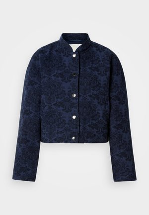 Μπλε ναυτικό cropped σακάκι με περίπλοκη υφή λουλουδιών, που διαθέτει όρθιο γιακά και ασημένια κουμπιά πίεσης στο μπροστινό μέρος.