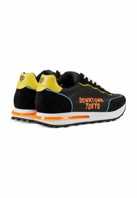 Sneaker in suede nero e mesh con accenti gialli, suola arancione e "DOWNTOWN TOKYO" in vivace arancione. Presentano un collare imbottito e un design con lacci.