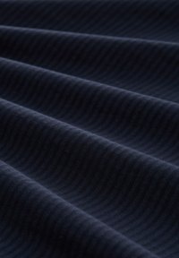 Tessuto blu scuro con una texture a coste, caratterizzato da sottili motivi a onde sulla superficie, che creano profondità e interesse visivo.