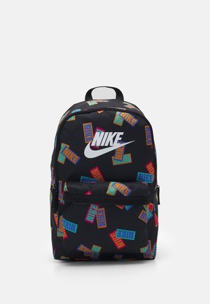 Mochila negra de Nike con logotipos de Nike coloridos dispersos y un gran logo blanco de Nike en la parte frontal, con un bolsillo frontal con cremallera y asa superior.