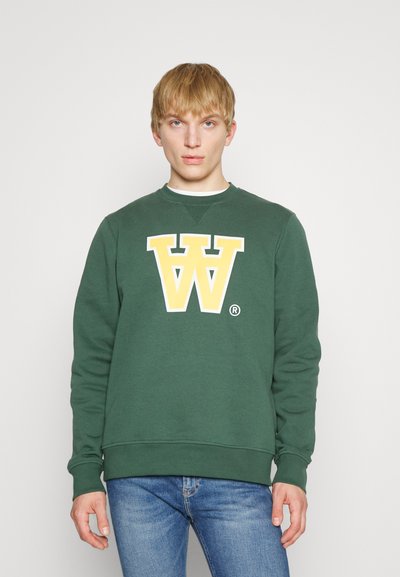 Grüner Pullover mit einem großen gelb-weißen Buchstaben "W" Logo auf der Vorderseite, gerippten Bündchen und Saum sowie einem Rundhalsausschnitt.
