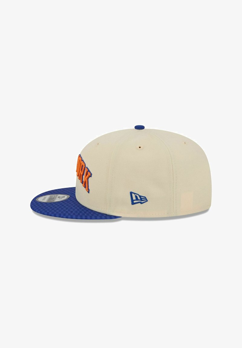 Cream-colored cap with a blue checkered brim. Features orange "NEW YORK" embroidery on the front and a blue logo on the side.