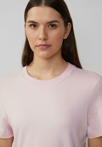 Helles rosa T-Shirt mit kurzen Ärmeln und rundem Halsausschnitt. Weiches Baumwollmaterial mit glatter Textur und subtilen Nähdetails.