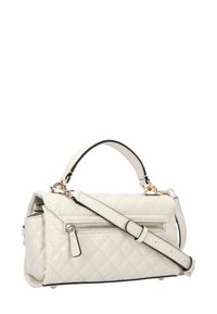 Sac à main matelassé de couleur crème avec une poignée supérieure, une bandoulière ajustable et une poche zippée extérieure sur le côté.