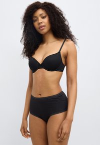 Μαύρο σουτιέν με λείες θήκες και ρυθμιζόμενους ιμάντες, σε συνδυασμό με μαύρο, ψηλόμεσο σλιπ με οδοντωτή άκρ η.