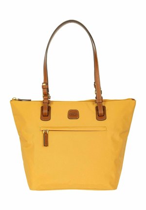 Gele draagtas met bruine leren handgrepen, voorvak met rits en een klein gebrandmerkt leren patch onder de rits.
