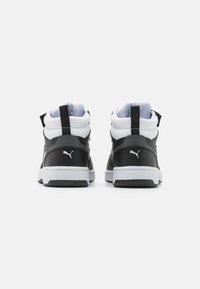 Zwart-witte mid-top sneakers zijn voorzien van een gladde leren bovenkant, een gevoerde kraag en een trekkoord; rubberen zool met gestructureerde accenten.