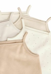Drei Spaghettiträger-Tops aus weichem Beige- und Creme-Stoff. Merkmale sind dünne Träger, gewellte Kanten und Muster aus kleinen Blumen und Punkten.