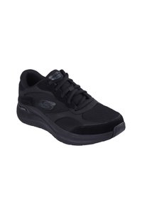 Scarpa sportiva nera con tomaia in rete, accenti in suede, collo imbottito e suola in gomma testurizzata. Chiusura con lacci e dettaglio del logo.