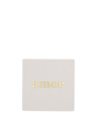 Piastrella quadrata in ceramica bianca con la parola dorata in rilievo "amor" centrata su uno sfondo bianco semplice.