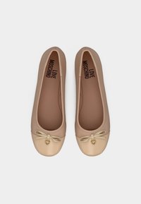 Μπεζ μπαλαρίνες με μεταλλικές χρυσές μύτες, μικρό φιόγκο και καρδιόσχημο γούρι, με την επιγραφή "Love Moschino" στο εσωτερικό.