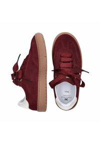 Un paio di sneaker in suede bordeaux con lacci spessi abbinati e suole in gomma beige, mostrati in vista laterale e dall'alto su sfondo bianco.